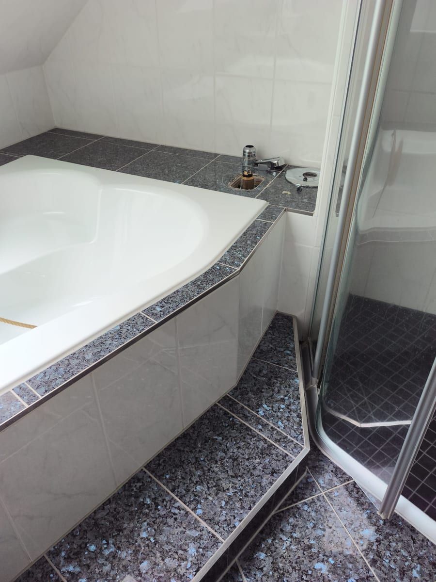 Eckbadewanne und Dusche in einem Bad mit Dachschräge
